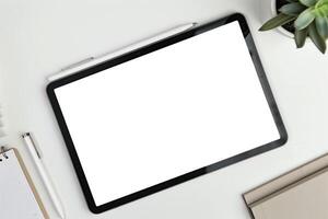 Tablet on Desk with Pen and Notepad and Desk Lamp photo