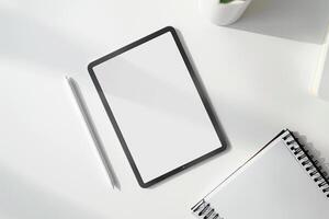 Tablet on Desk with Pen and Notepad and Keyboard photo