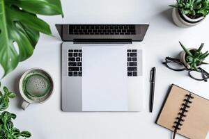 Laptop Mockup with Open Notebook on White Desk with Writing Materials photo