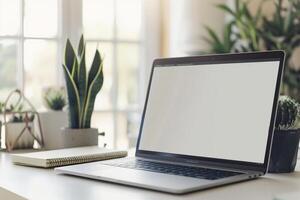 Laptop Mockup on White Desk with Open Notebook and Writing Materials photo