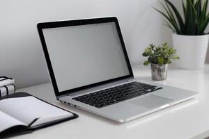 Laptop Mockup with Blank Notebook Open on White Desk photo