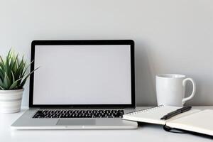 Laptop Mockup with Blank Notebook Open on White Desk photo