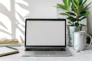 Laptop Mockup with Blank Notebook Open on White Desk photo