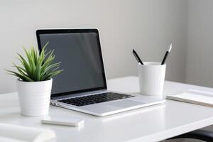 Laptop Mockup with Blank Notebook Open on White Desk photo