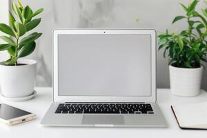 Laptop Mockup with Blank Notebook Open on White Desk photo