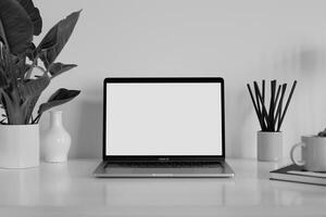 Laptop Mockup with Blank Notebook Open on White Desk photo