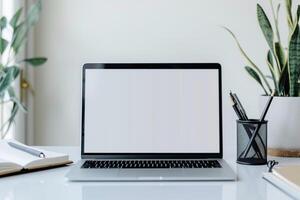 Laptop Mockup Background on a White Desk with Open Notebook and   Writing Setup photo