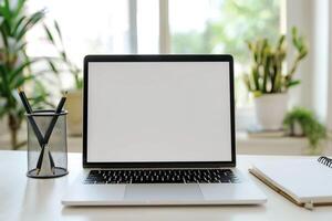 Writing Setup with Laptop Mockup and Open Notebook on White Desk Background photo
