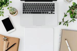 Writing Setup with Laptop Mockup and Open Notebook on White Desk Background photo