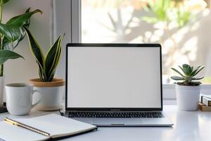 Laptop Mockup with White Desk and Open Notebook for   Work and Writing Setup photo