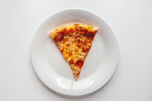 Desktop arrangement with a slice of pizza on a white plate photo