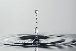 Single Water Droplet Falling into a Pool of Water Creating Gentle Ripples photo