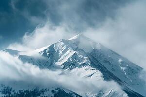 Snow Capped Mountain Peak at Dawn with Mist and Majestic Winter Landscape Under a Beautiful Sky photo