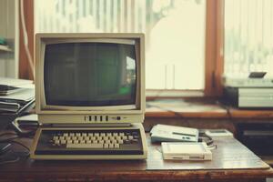 Retro Computer Mockup with CRT Monitor and Floppy Disks on a Wooden Desk photo