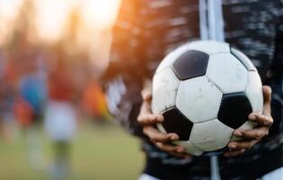 Soccer Ball in Goal Net at Sunset photo