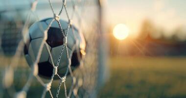 Soccer Ball in Goal Net at Sunset photo