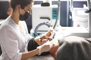 Cosmetician working with client in clinic photo