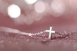Silver Cross Necklace on Pink Background photo