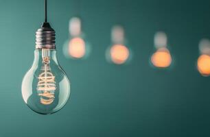 Single Lightbulb Hanging Against Teal Wall photo
