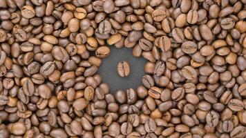 Coffee beans. Roasted coffee beans. Aromatic roasted coffee with a coffee bean in the center. View from the top. video
