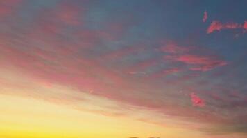 Sky time lapse during sunset time is a stunning display of warm colors, ranging from orange and pink to purple and red, creating a beautiful and serene. Left to right dramatic clouds pass slowly video