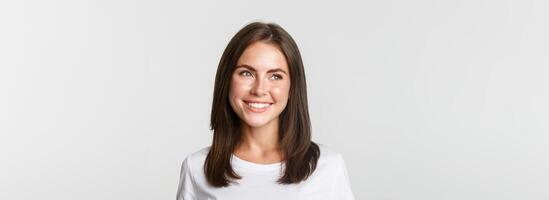 Portrait of attractive thoughtful girl smiling and looking left, white background photo