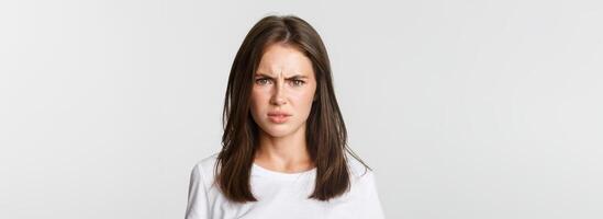 Close-up of skeptical and displeased attractive girl shaking head in rejection, frowning disappointed photo