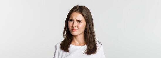 Close-up of skeptical and displeased attractive girl shaking head in rejection, frowning disappointed photo