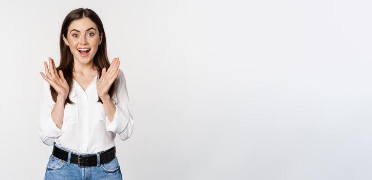 entusiasta riendo mujer, sonriente divertido, aplausos manos, aplaudiendo, en pie en formal atuendo terminado blanco antecedentes foto