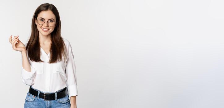 retrato de hembra oficina obrero, mujer de negocios mirando a cámara y sonriente, en pie terminado blanco antecedentes foto