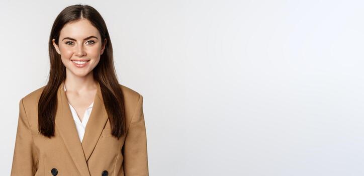 retrato de negocio mujer con entusiasta cara expresión, sonriente, mirando seguro, en pie en traje terminado blanco antecedentes foto