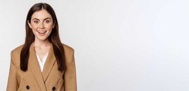 retrato de negocio mujer con entusiasta cara expresión, sonriente, mirando seguro, en pie en traje terminado blanco antecedentes foto