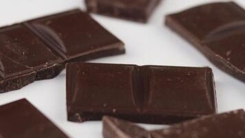 Pieces of dark chocolate on a white background isolate video