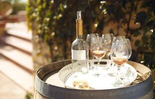 Many glasses and bottle of rose wine in the autumn vineyard photo