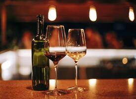 Wine bottle and glasses on the table, against the background of wine dinner. photo