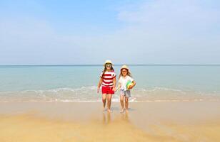 Happy sisters playing in sand on a beautiful beach photo