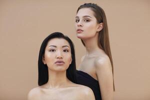 Two beautiful multicultural young women hugging while posing camera photo