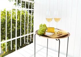 Wine with grapes and cheese on terrace photo