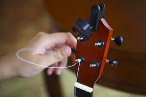 Process of changing string of ukulele photo
