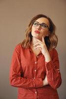 Portrait of attractive brunette woman with eyeglasses wearing red blouse photo