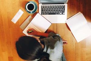Unrecognizable freelancer making notes and working on floor photo