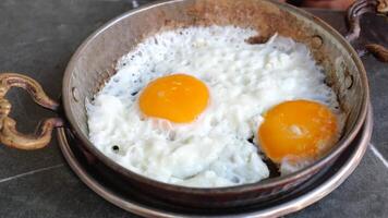 Indulge in a simple and delicious rustic breakfast with fried eggs cooked in a castiron skillet video