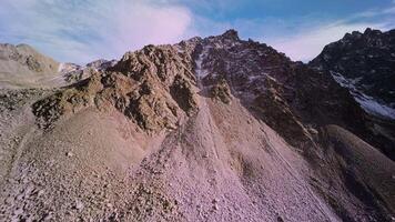 Aerial view, climbing to the top of the mountain preparing for a dive from the upper ridge, alpine sunny landscape. Sports drone with first person view, epic rocky landscape. video
