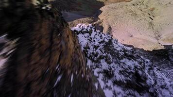 Jump from the top of a rocky mountain down under the rocks. Sport fpv drone flying over rocky mountain slope. Breathtaking footage of a dynamic fall from a cliff video