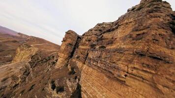Aerial view, climbing to the top of the mountain preparing for a dive from the upper ridge, alpine sunny landscape. Sports drone with first person view, epic rocky landscape. video
