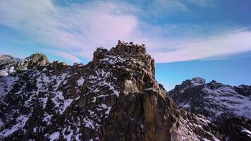Aerial view, climbing to the top of the mountain preparing for a dive from the upper ridge, alpine sunny landscape. Sports drone with first person view, epic rocky landscape. video