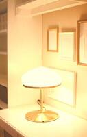 Glowing lamp on table with empty frames above photo