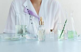 Woman examining green plant in laboratory photo