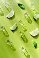 Fresh mint leaf and ice cubes with droplets and lime on green background photo