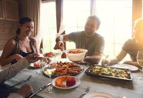 Table with white wine, shrimps, salad and graten photo